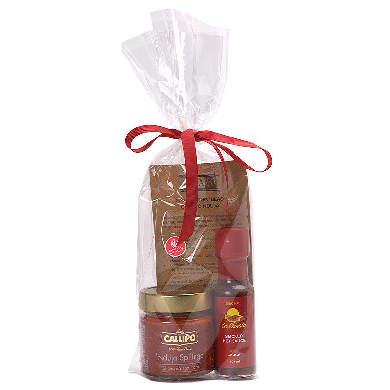 A gift set of hot sauce and jar of nduja in a clear cellophane bag tied with a red ribbon. Sabato | Auckland, New Zealand.