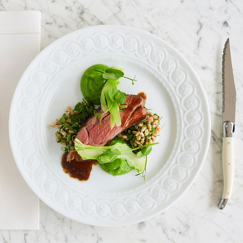 Slice of lamb shank on a bed of barley with fresh greens | Shop Sabato Auckland